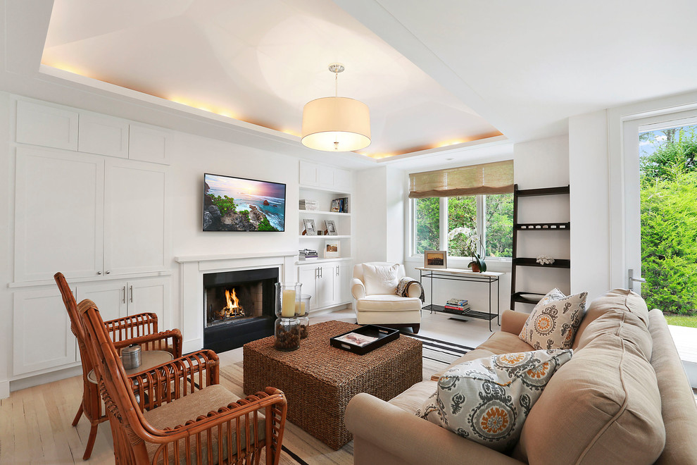 Immagine di un soggiorno costiero con pareti bianche, parquet chiaro, camino classico e TV a parete