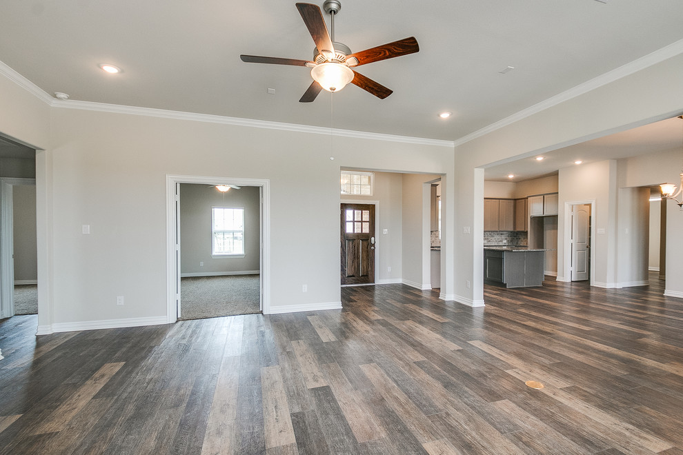 This is an example of a medium sized traditional open plan games room in Houston with a corner fireplace, a stone fireplace surround and brown floors.