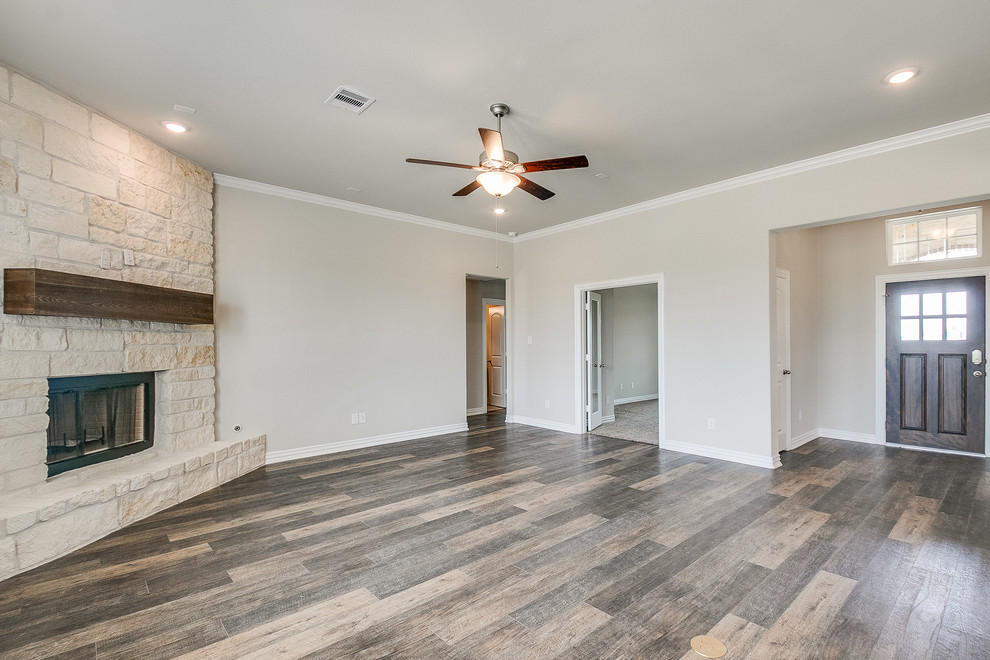 Mittelgroßes, Offenes Klassisches Wohnzimmer mit Eckkamin, Kaminumrandung aus Stein und braunem Boden in Houston