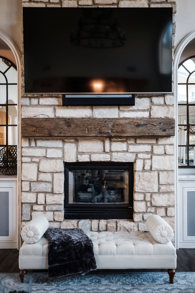 Large open plan games room in Houston with porcelain flooring, a two-sided fireplace, a stone fireplace surround, a wall mounted tv and brown floors.