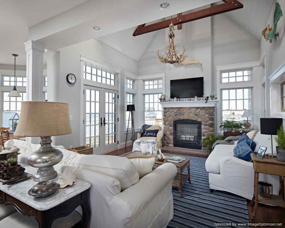 Mid-sized beach style open concept medium tone wood floor family room photo in Philadelphia with white walls, a standard fireplace, a stone fireplace and a wall-mounted tv