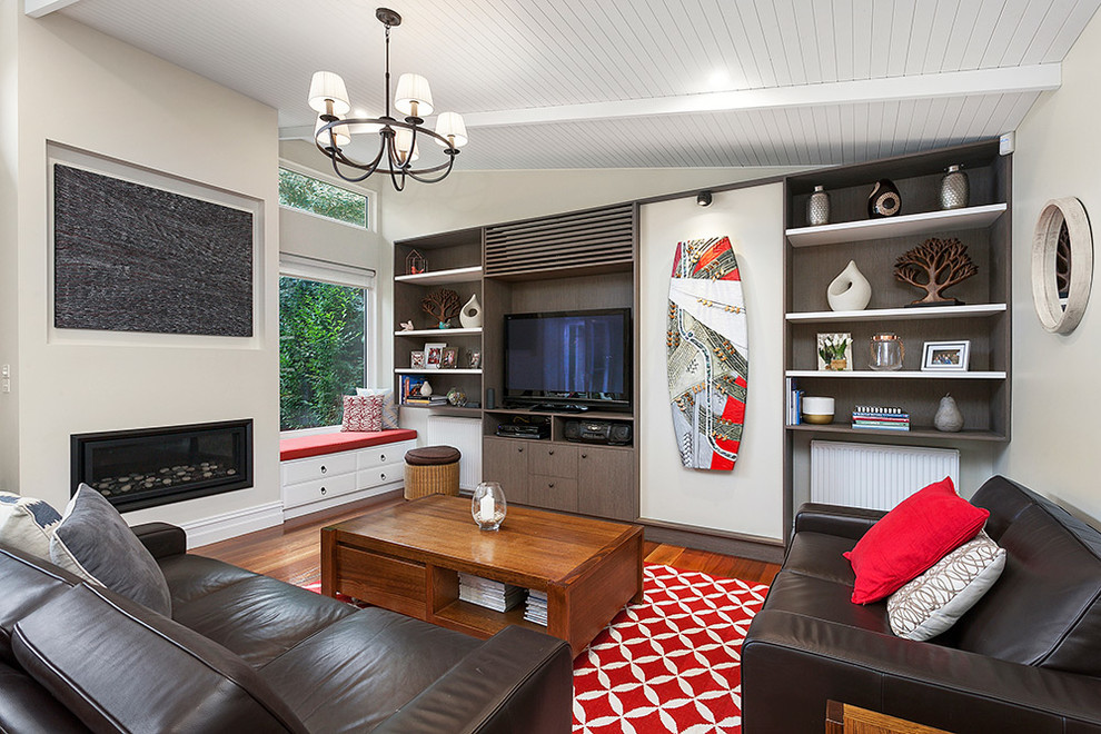 Offenes Modernes Wohnzimmer mit beiger Wandfarbe, braunem Holzboden, Kamin, Kaminumrandung aus Metall und braunem Boden in Melbourne