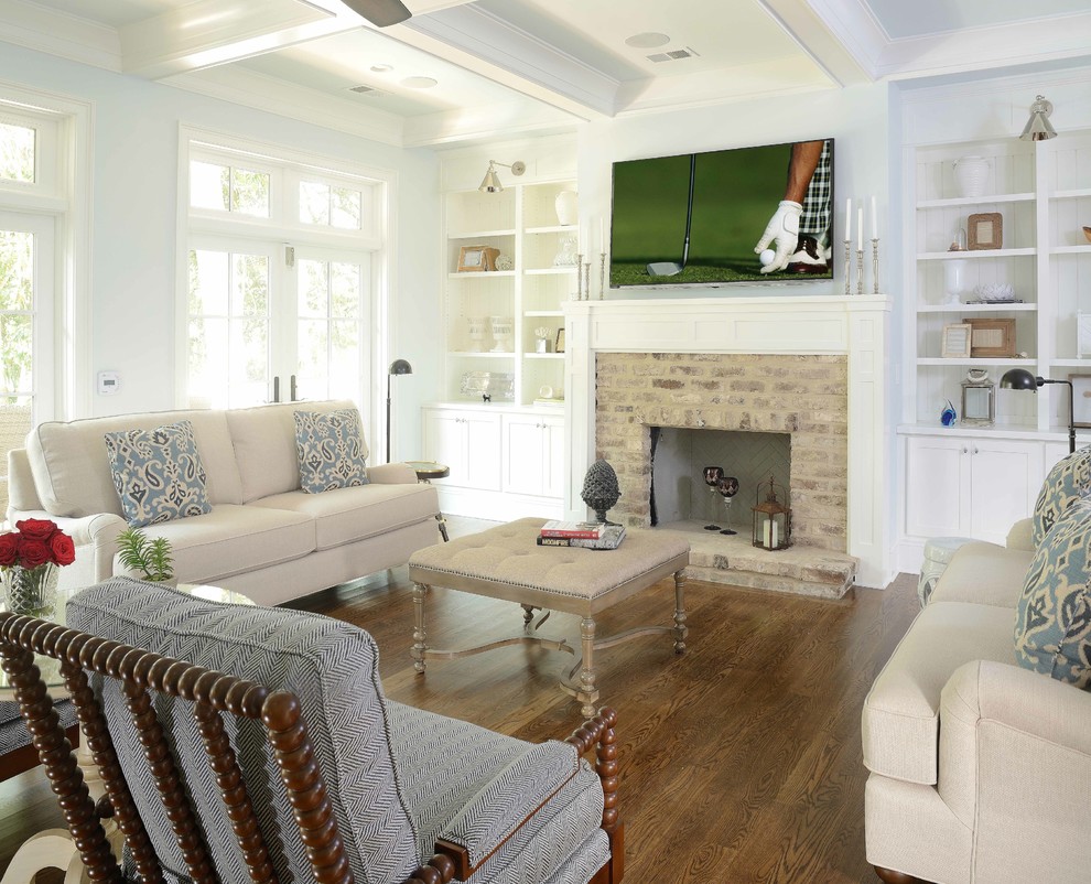 This is an example of a nautical living room in Charleston with white walls, dark hardwood flooring, a wall mounted tv, a standard fireplace and a stone fireplace surround.