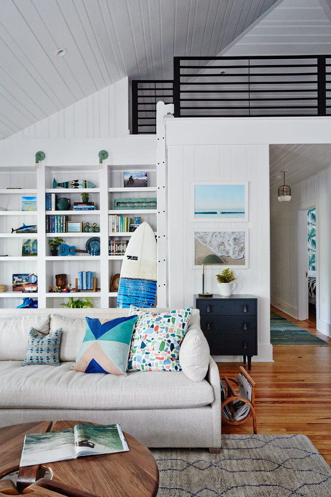 Family room - coastal open concept medium tone wood floor family room idea in Charleston with white walls