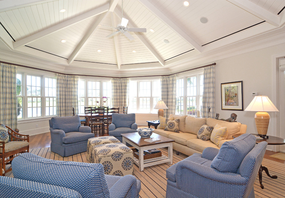 Modelo de sala de estar abierta marinera grande con paredes blancas y suelo de madera en tonos medios