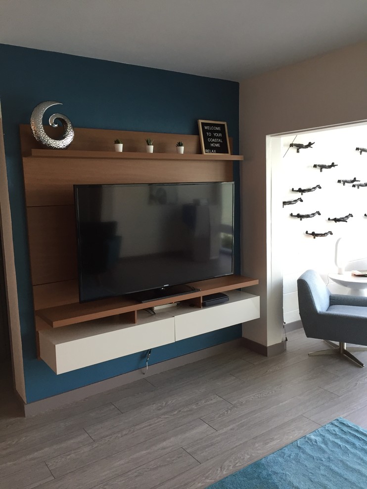 Foto på ett litet funkis allrum, med blå väggar, linoleumgolv, en väggmonterad TV och grått golv
