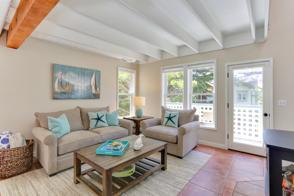 Immagine di un soggiorno stile marinaro di medie dimensioni e aperto con pareti beige, pavimento in terracotta, stufa a legna e nessuna TV