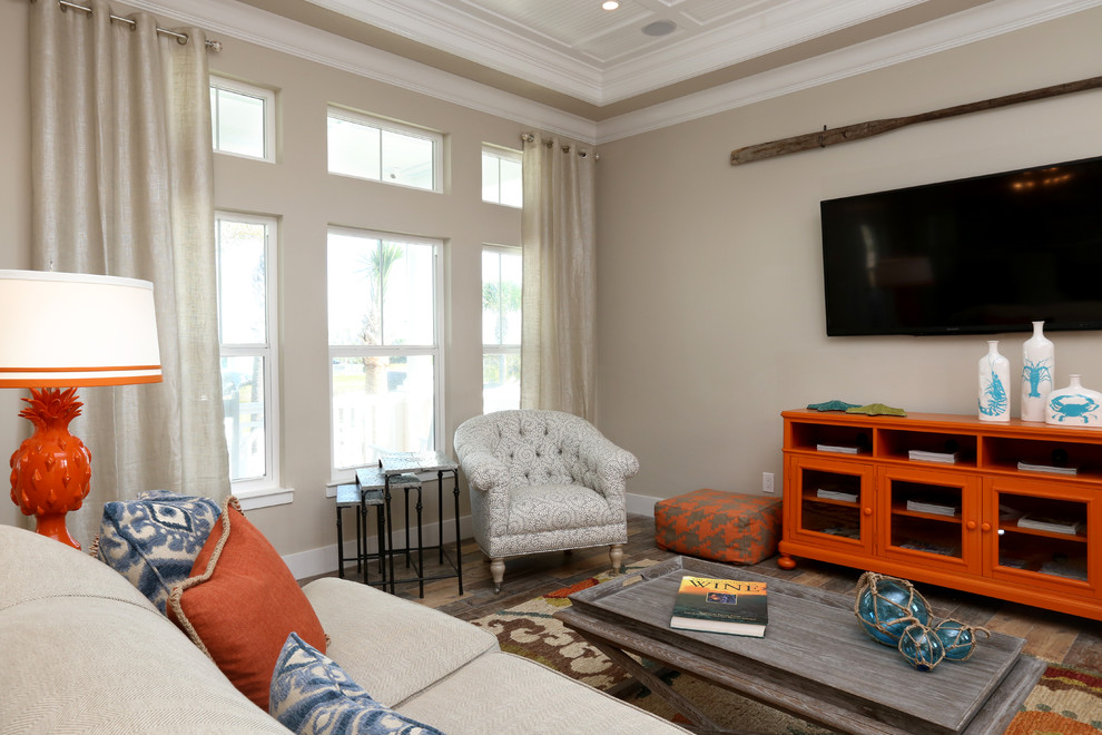 Esempio di un soggiorno stile marino di medie dimensioni e aperto con pareti beige, TV a parete e pavimento in legno massello medio