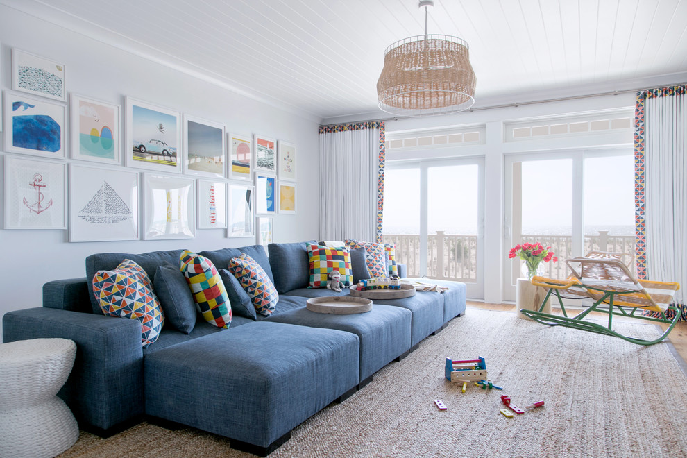 Пример оригинального дизайна: большая открытая гостиная комната в морском стиле с белыми стенами, паркетным полом среднего тона, мультимедийным центром, коричневым полом и синим диваном без камина