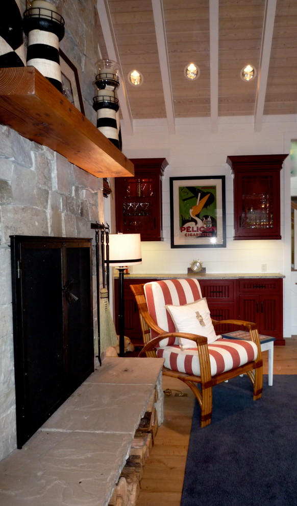 Imagen de sala de estar abierta marinera grande con paredes blancas, suelo de madera en tonos medios, todas las chimeneas, marco de chimenea de piedra y pared multimedia