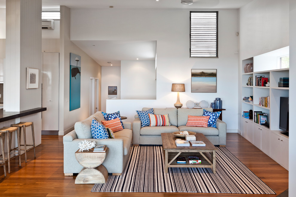 Offenes Modernes Wohnzimmer mit weißer Wandfarbe, braunem Holzboden und Multimediawand in Brisbane