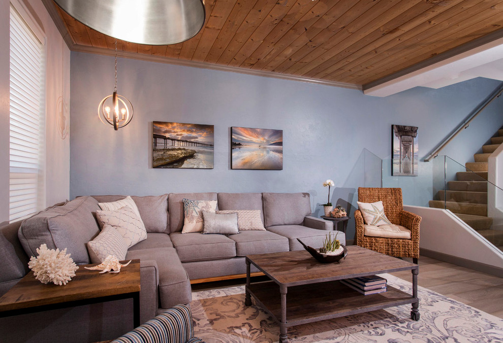 Idées déco pour une salle de séjour bord de mer de taille moyenne et ouverte avec un mur bleu, parquet clair et un sol gris.