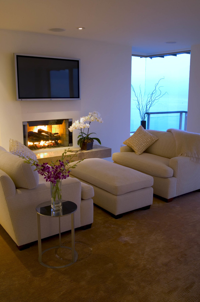 Foto de sala de estar costera con paredes blancas, suelo de piedra caliza y marco de chimenea de yeso