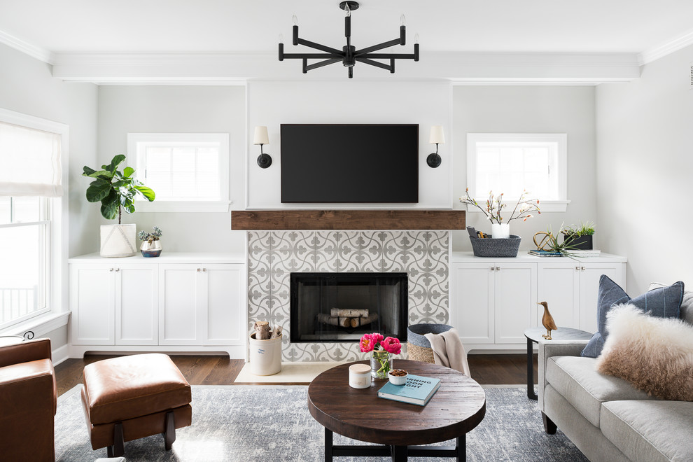 This is an example of a medium sized nautical games room in Chicago with grey walls, a standard fireplace, a tiled fireplace surround, a wall mounted tv, brown floors and dark hardwood flooring.