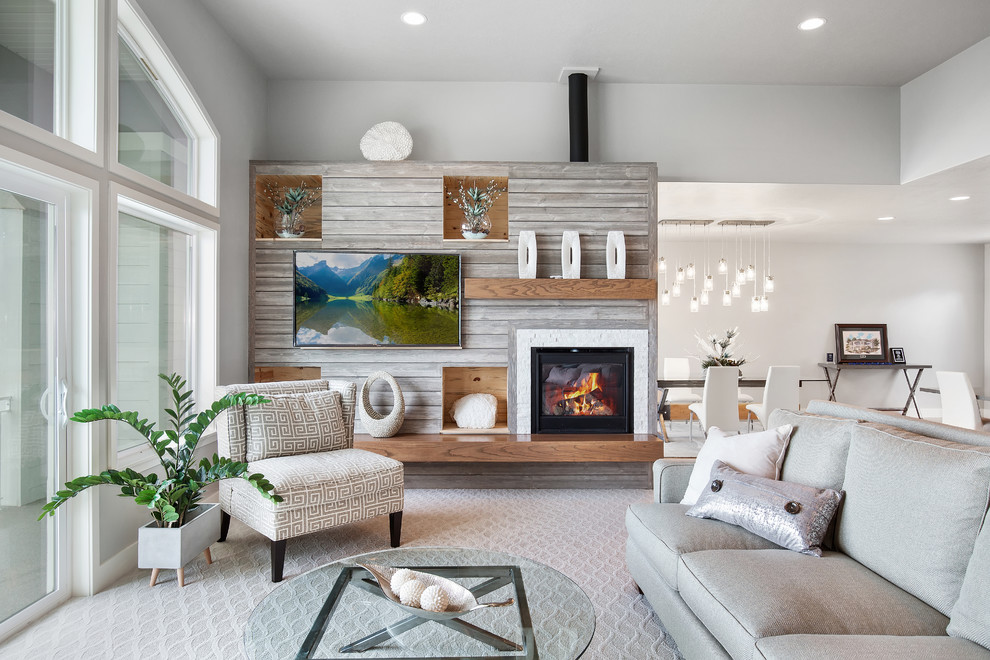 На фото: открытая гостиная комната в морском стиле с серыми стенами, ковровым покрытием, стандартным камином, телевизором на стене и серым полом