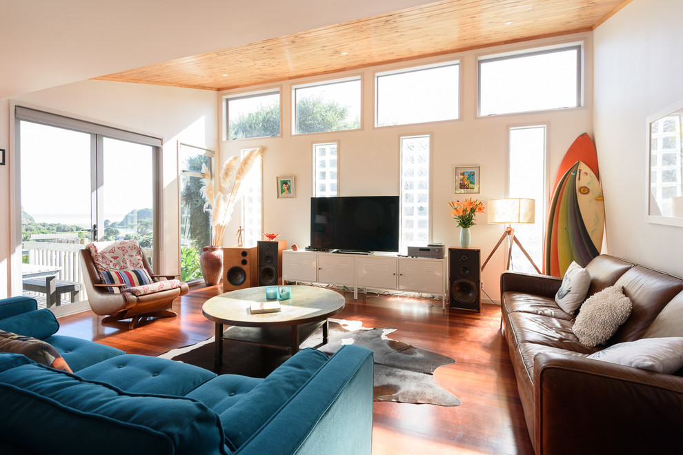 Modelo de sala de estar costera con paredes blancas, suelo de madera oscura y televisor independiente