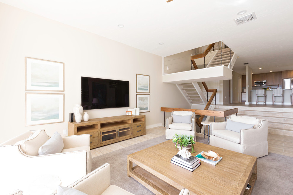 Ejemplo de sala de estar abierta clásica renovada de tamaño medio con paredes beige, suelo de baldosas de porcelana, televisor colgado en la pared y suelo beige