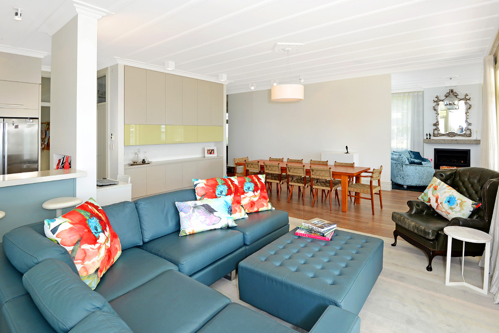 Esempio di un soggiorno bohémian di medie dimensioni e aperto con pareti bianche, pavimento in laminato e pavimento marrone