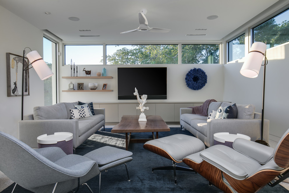 Foto de sala de estar abierta marinera de tamaño medio sin chimenea con paredes blancas, suelo de cemento, televisor colgado en la pared y suelo blanco