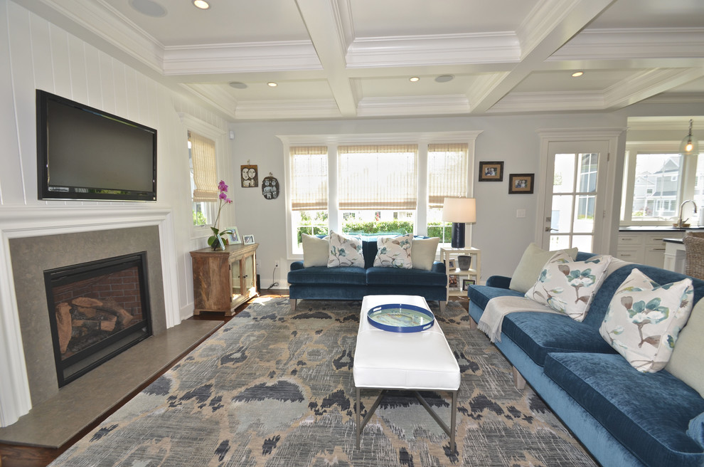 Example of a mid-sized transitional open concept dark wood floor family room design in New York with white walls, a standard fireplace, a stone fireplace and a wall-mounted tv