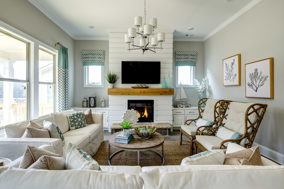 На фото: гостиная комната в морском стиле с серыми стенами, стандартным камином, телевизором на стене и красивыми шторами с