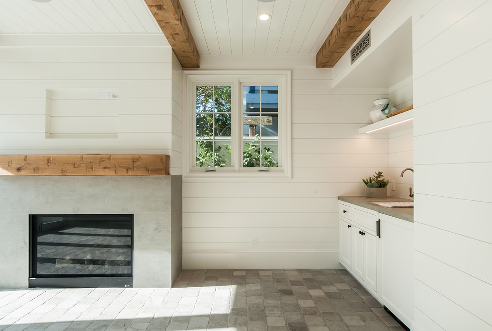 Cette photo montre une salle de séjour nature fermée avec un mur blanc, un sol en calcaire, une cheminée standard, un manteau de cheminée en béton et un sol gris.