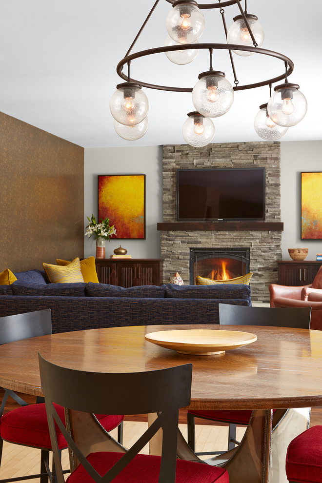 Medium sized contemporary open plan games room in Minneapolis with grey walls, dark hardwood flooring, a standard fireplace, a stone fireplace surround and a wall mounted tv.