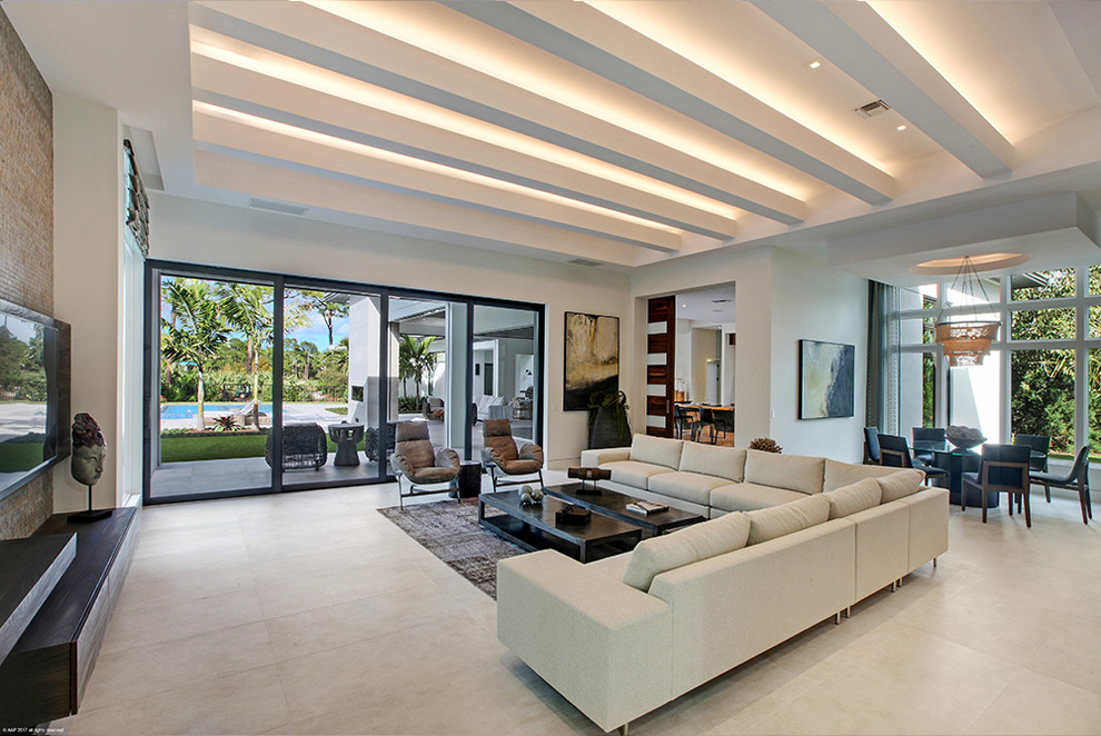 Geräumiges, Offenes Modernes Wohnzimmer ohne Kamin mit Keramikboden, TV-Wand und beigem Boden in Miami