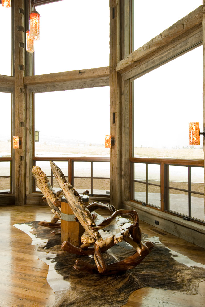 Example of a mountain style medium tone wood floor family room design in Other