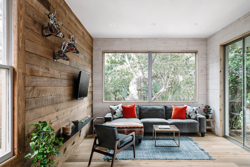 Foto de sala de estar rústica sin chimenea con paredes beige, suelo de madera clara y televisor colgado en la pared