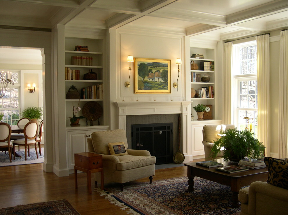 Imagen de sala de estar abierta clásica de tamaño medio sin televisor con paredes blancas, suelo de madera en tonos medios, todas las chimeneas y marco de chimenea de madera