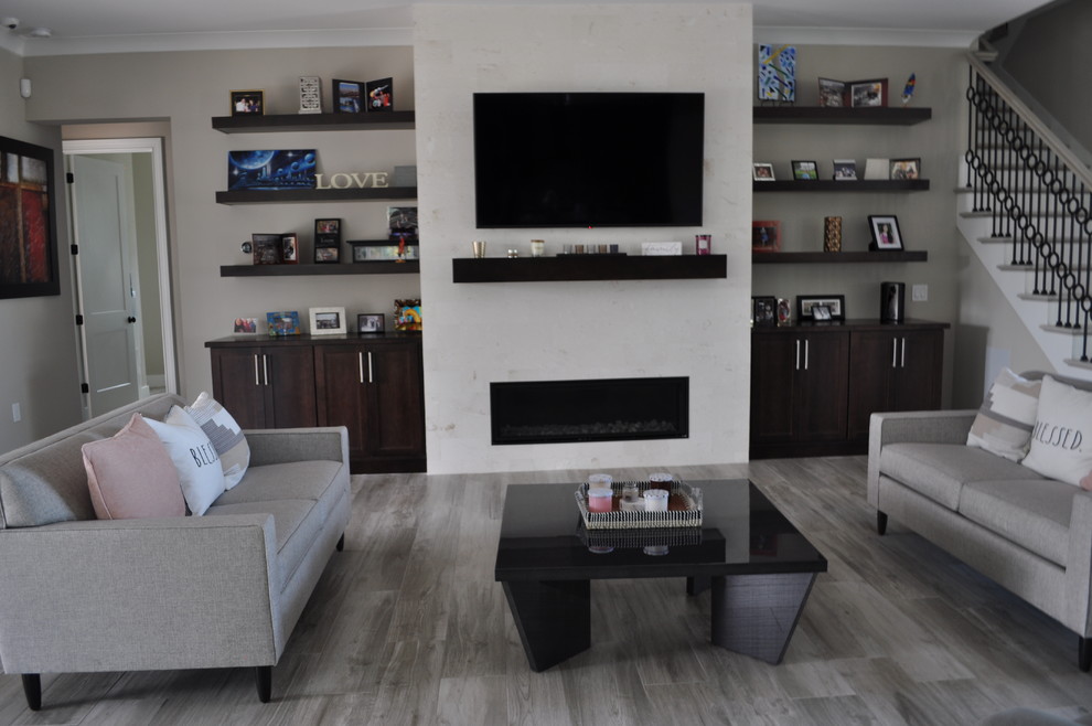 Cette photo montre une grande salle de séjour moderne ouverte avec un mur blanc, parquet clair, une cheminée standard, un manteau de cheminée en carrelage, un téléviseur fixé au mur et un sol gris.