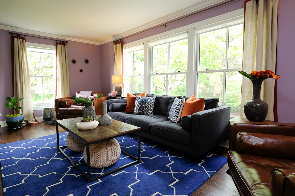 На фото: изолированная гостиная комната среднего размера в стиле неоклассика (современная классика) с фиолетовыми стенами, паркетным полом среднего тона, двусторонним камином, фасадом камина из камня, телевизором на стене и ковром на полу с
