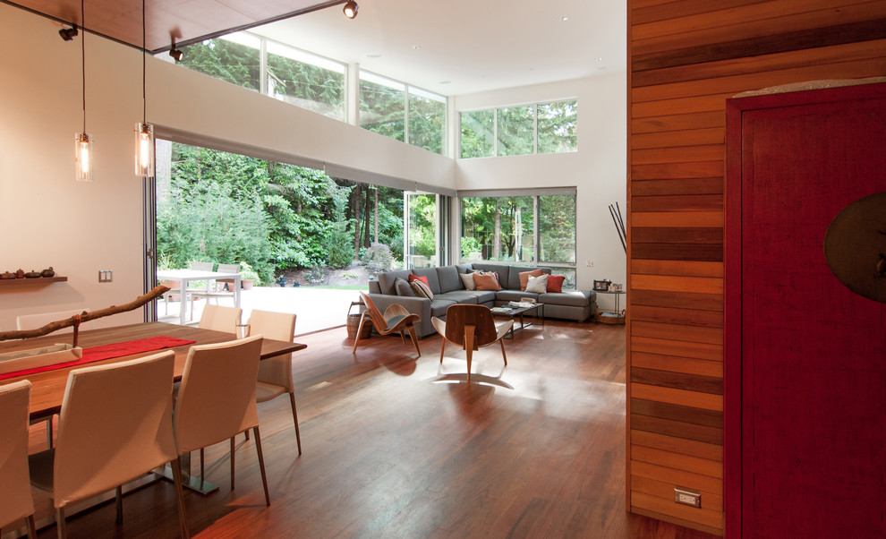 This is an example of a large contemporary open plan games room in Seattle with beige walls, dark hardwood flooring, no tv and brown floors.
