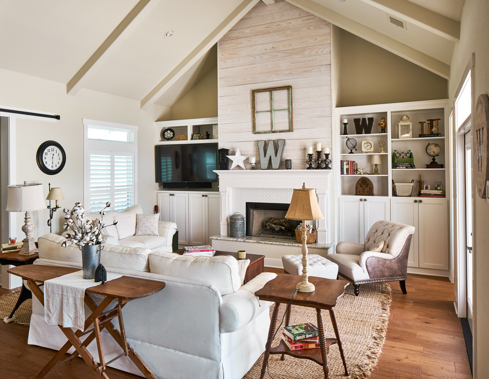 Landhausstil Wohnzimmer mit beiger Wandfarbe, braunem Holzboden, Gaskamin, gefliester Kaminumrandung und Multimediawand in Sonstige