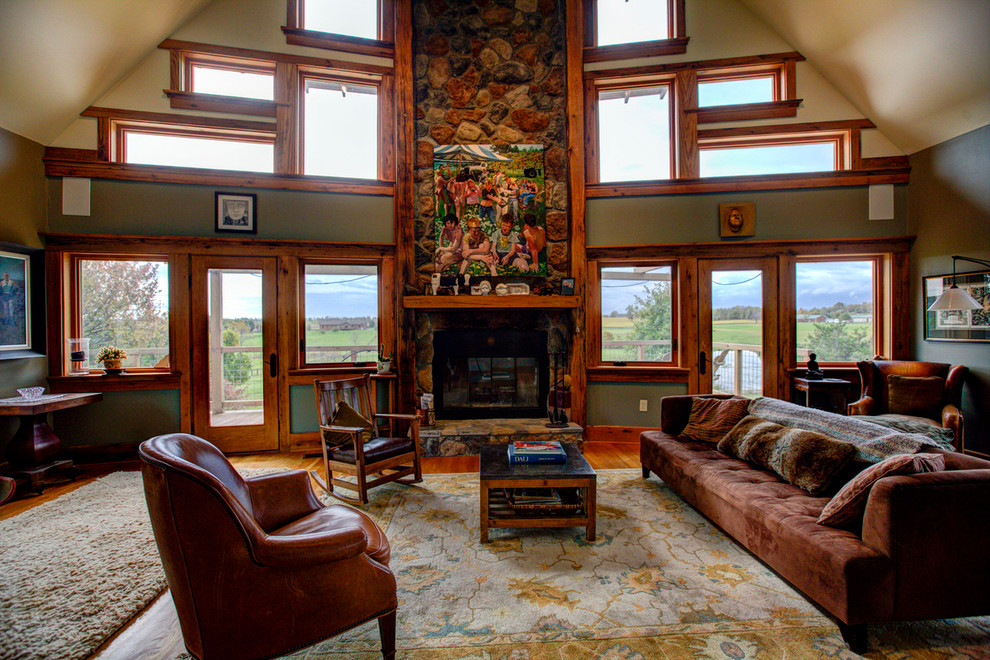 Modelo de sala de estar abierta de estilo americano con paredes verdes, suelo de madera en tonos medios, todas las chimeneas y marco de chimenea de madera