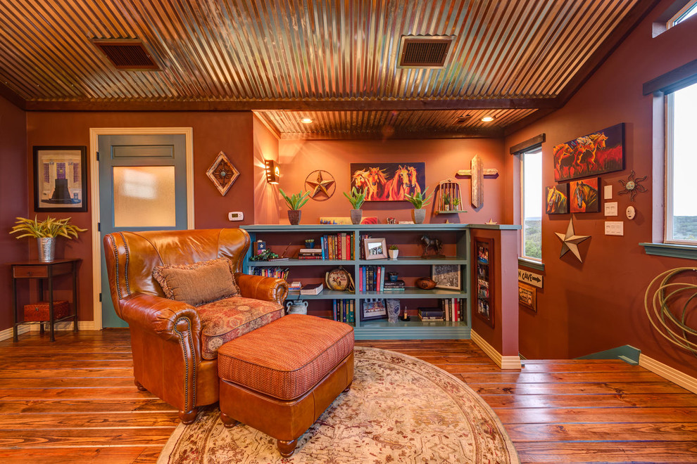 Стильный дизайн: двухуровневая гостиная комната в стиле фьюжн с с книжными шкафами и полками, оранжевыми стенами, паркетным полом среднего тона и оранжевым полом - последний тренд