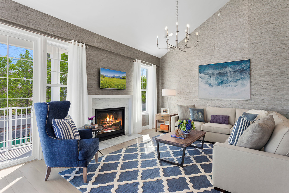 Идея дизайна: гостиная комната в стиле неоклассика (современная классика) с серыми стенами, светлым паркетным полом, стандартным камином и телевизором на стене