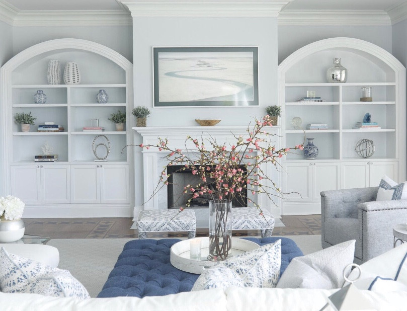 Стильный дизайн: большая открытая гостиная комната в стиле неоклассика (современная классика) с синими стенами, ковровым покрытием, стандартным камином, фасадом камина из дерева, телевизором на стене и синим полом - последний тренд