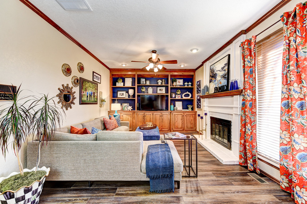 Mittelgroßes, Offenes Klassisches Wohnzimmer mit beiger Wandfarbe, braunem Holzboden, Kamin, Kaminumrandung aus Backstein und Multimediawand in Oklahoma City