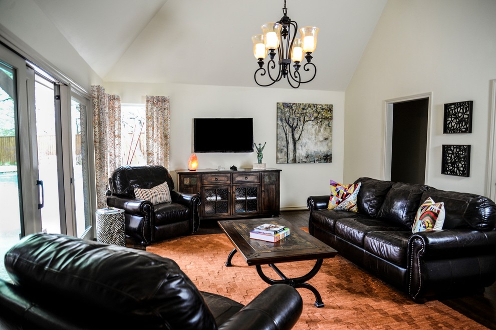 Modelo de sala de estar abierta clásica de tamaño medio sin chimenea con paredes amarillas, suelo de madera en tonos medios, televisor independiente y suelo marrón