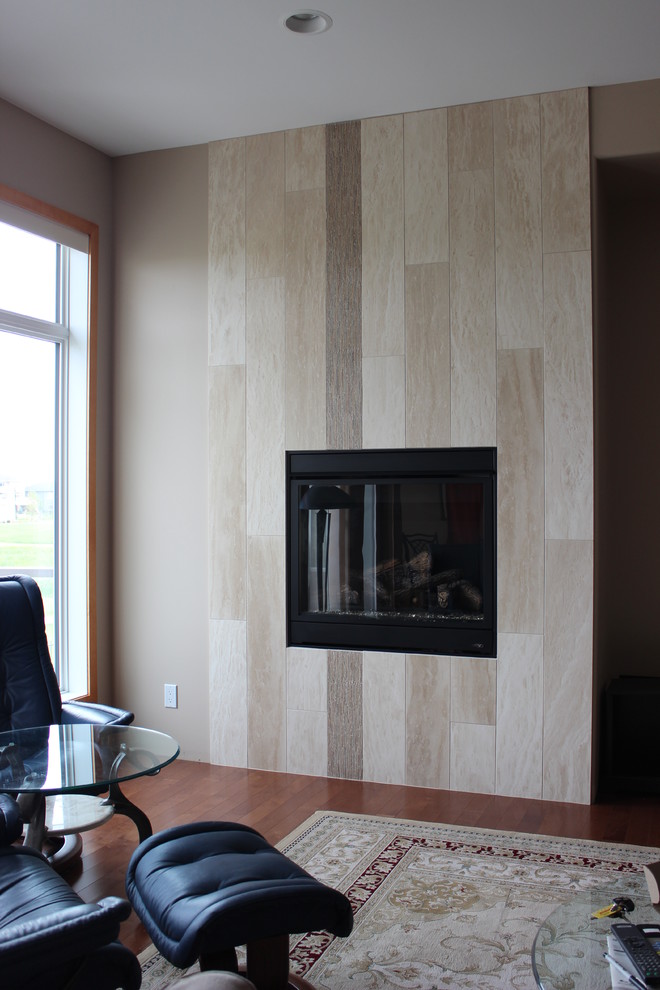 This is an example of a medium sized modern open plan games room in Phoenix with beige walls, a standard fireplace and a tiled fireplace surround.