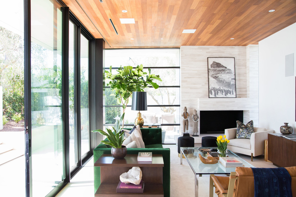 Mittelgroßes, Abgetrenntes Modernes Wohnzimmer mit Hausbar, weißer Wandfarbe, Kalkstein, Eckkamin, gefliester Kaminumrandung und TV-Wand in Los Angeles