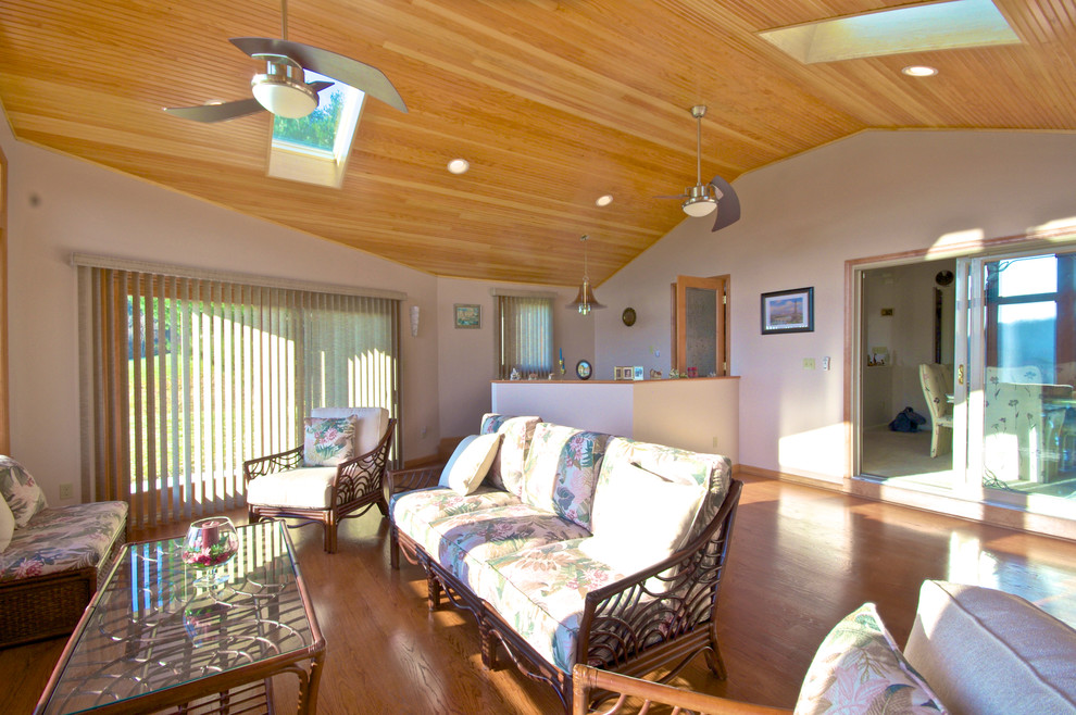 Modelo de sala de estar abierta tradicional grande con paredes blancas y suelo de madera en tonos medios