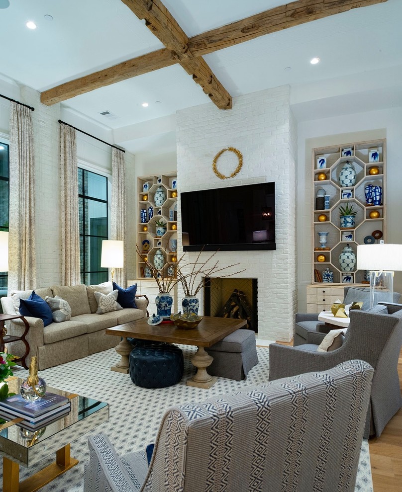 Imagen de sala de estar abierta tradicional renovada grande con paredes blancas, suelo de madera clara, todas las chimeneas, marco de chimenea de ladrillo y televisor colgado en la pared