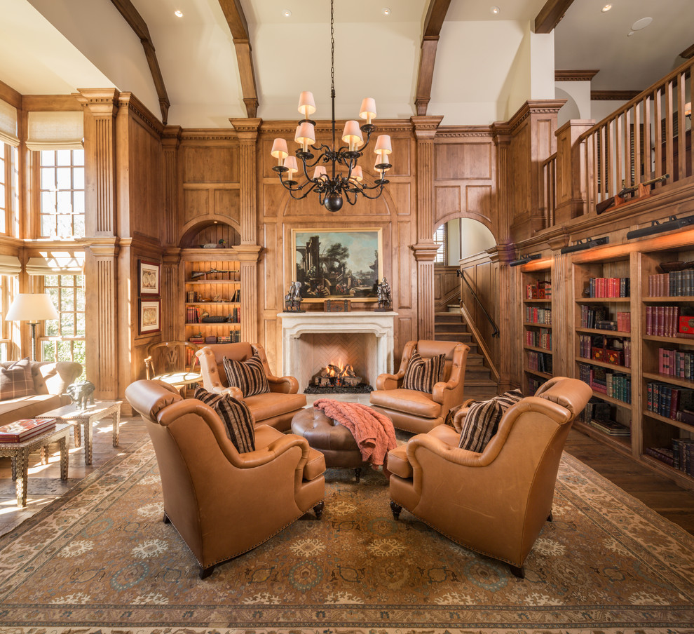 Foto de sala de estar con biblioteca cerrada clásica con paredes marrones, suelo de madera oscura, todas las chimeneas, marco de chimenea de piedra y suelo marrón