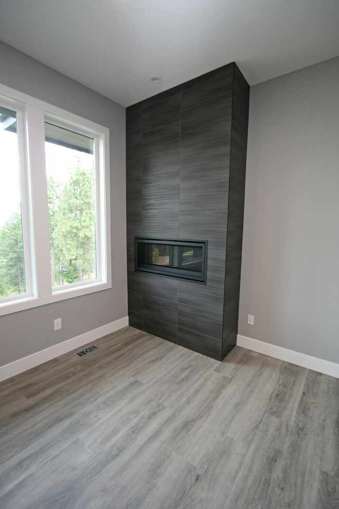 Inspiration for a mid-sized contemporary open concept vinyl floor and gray floor family room remodel in Seattle with gray walls, a ribbon fireplace, a tile fireplace and a wall-mounted tv