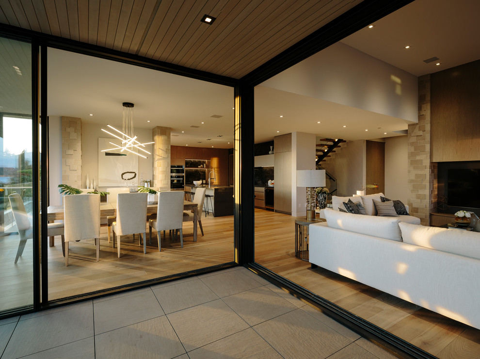 Idée de décoration pour une grande salle de séjour design ouverte avec un sol en bois brun et un téléviseur fixé au mur.