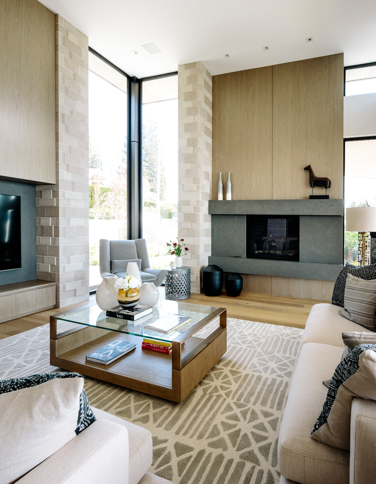 Diseño de sala de estar abierta actual grande con suelo de madera en tonos medios, todas las chimeneas, marco de chimenea de piedra y televisor colgado en la pared