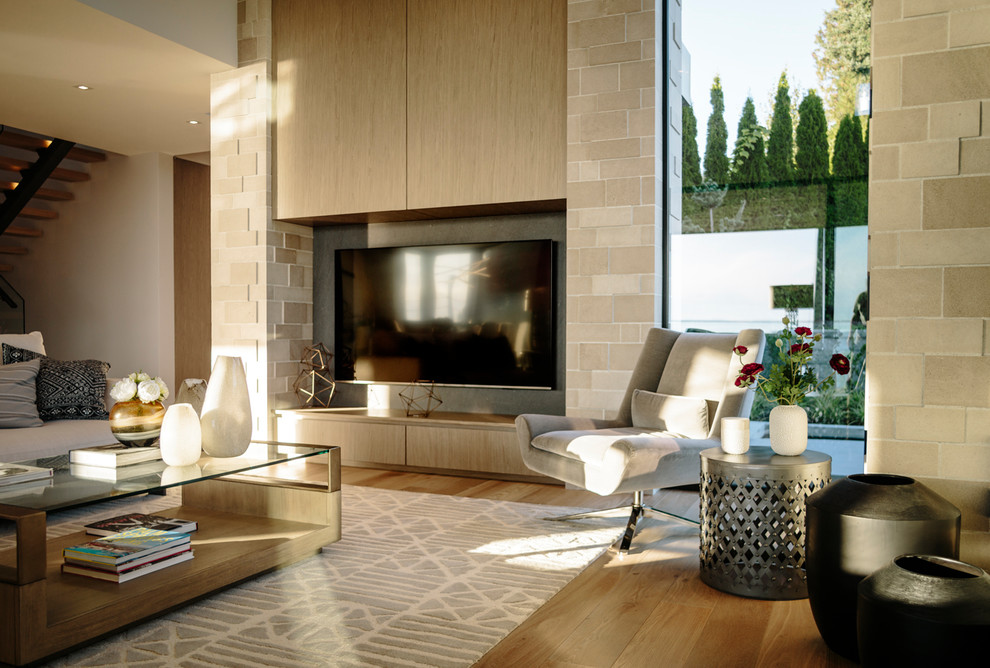 Modelo de sala de estar abierta contemporánea grande con suelo de madera en tonos medios y televisor colgado en la pared
